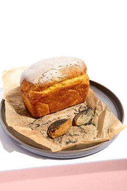 Mısır ekmeği beyaz masada. Beyaz masa ve güneş ışığında sert gölgeli pembe duvar. Yaz günü yemekleri konsepti