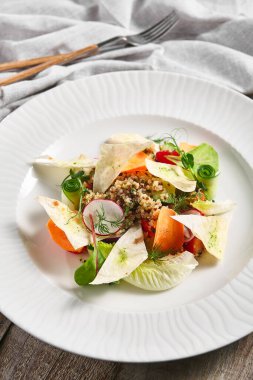 Sebzeli kinoa salatası. Restoran vejetaryen yemek tabağı ahşap masada. Sebze, sağlıklı, organik akşam yemeği konsepti..