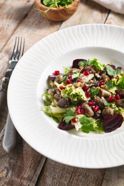 Sıcak tavuk ciğeri ve pancar salatası. Restoran yemek tabağı ahşap masada. Sebzeler, sağlıklı, organik gıda konsepti.