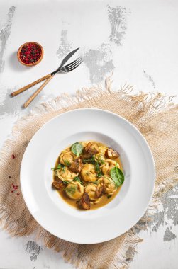 Hamur köftesi Restoran Tabağı. Kremalı Porcini soslu hamur tatlısı. Beyaz masadaki beyaz restoran tabağı. Kırsal restoran yemek konsepti