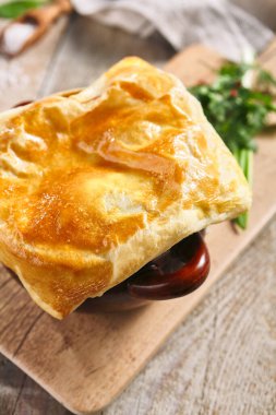 Ekmekli mantar çorbası. Tahta masadaki kahverengi tencerede lezzetli yemekler. Kırsal tarzda yemek.