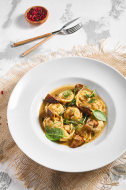 Hamur köftesi Restoran Tabağı. Kremalı Porcini soslu hamur tatlısı. Beyaz masadaki beyaz restoran tabağı. Kırsal restoran yemek konsepti