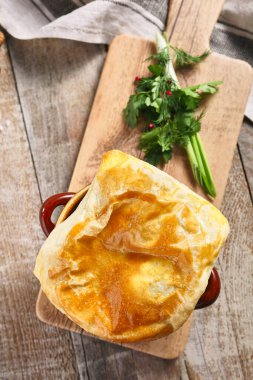 Ekmekli mantar çorbası. Tahta masadaki kahverengi tencerede lezzetli yemekler. Kırsal tarzda yemek. Üst görünüm