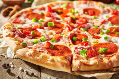 Pizza soslu Pepperoni pizza, mozzarella peyniri ve pepperoni. Tahta üzerinde pizza, ahşap masada malzemelerle.