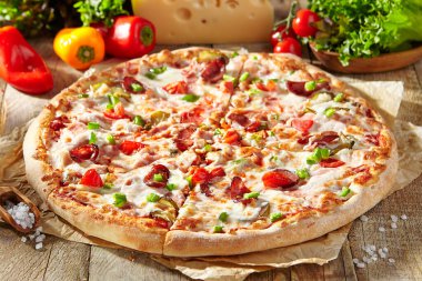 Pizza restoranının menüsü parşömenli et pizzası, üstüne de et sosisi ve pepperoni dilimi. İçinde pizza malzemeleri olan ahşap masa. Sert gölgeli güneş ışığı. Kırsal, doğal yemek.