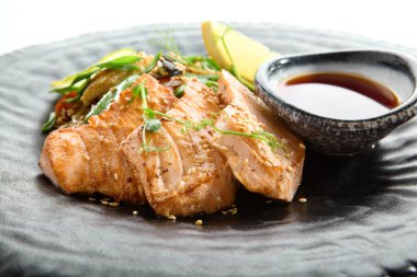 Teppanyaki stili somon - Soya soslu ızgara somon fileto ve sebze. Limon ve yeşil fasulye yaprağıyla süslenmiş Japon Teppanyaki Somon Bifteği. Siyah Asya plakası yakın görünüm