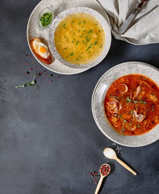 Çorba Seti - Tavuk ve Erişte Çorbası ve Solyanka (baharatlı ve ekşi çorba). Koyu kırsal masada yemek hazır. Üst manzara, düz uzanma