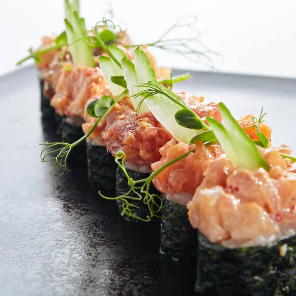 Gunkan Sushi Gunkan Maki Sushi与海鲜和辣酱 寿司和米饭在里面包裹着诺里海藻 美味的贡坎寿司在黑色板岩上因白人背景而被隔离 — 图库照片