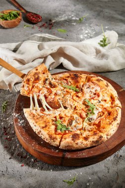 İtalyan Deniz Ürünleri Pizzası - Ahşap tabakta karışık deniz mahsullü pizza. Gri zemin üzerinde kırsal deniz ürünleri pizzası. Güneş ışığı ve sert gölge.