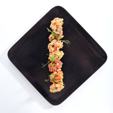 Gunkan Suşi, Gunkan Maki Suşi, deniz ürünleri ve baharatlı sos. İçinde pirinç olan suşi ve Norveç yosunu sarılmış. Siyah tabakta lezzetli Gunkan suşisi. Beyaz arka planda izole edilmiş. Üst görünüm 