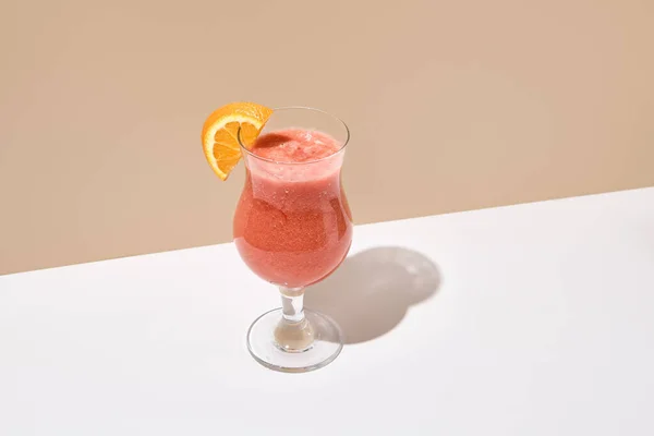 白桌子上放着橙子 香蕉和草莓的冰沙 夏季健康饮料的概念 米色的墙和白色的桌子 阳光和严酷的阴影 Smoothie酒吧菜单 — 图库照片