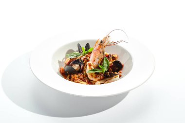Deniz mahsullü makarna, deniz ürünleri karışımlı spagetti tabağı. Karides, midye ve ahtapotlu makarna. Restoran gurmesi deniz ürünleri ve beyaz arka planda izole edilmiş makarna tabağı..