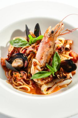 Deniz mahsullü makarna, deniz ürünleri karışımlı spagetti tabağı. Karides, midye ve ahtapotlu makarna. Restoran gurmesi deniz ürünleri ve beyaz arka planda izole edilmiş makarna tabağı..