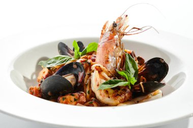 Deniz mahsullü makarna, deniz ürünleri karışımlı spagetti tabağı. Karides, midye ve ahtapotlu makarna. Restoran gurmesi deniz ürünleri ve beyaz arka planda izole edilmiş makarna tabağı..