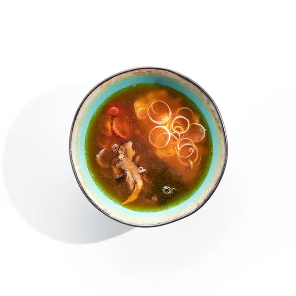 Japanese Miso Seafood Soup - traditional seafood soup with Japanese miso paste and seafood. Ingredients of soup include mushrooms, seaweed and seafood. Miso soup in bowl isolated on white background