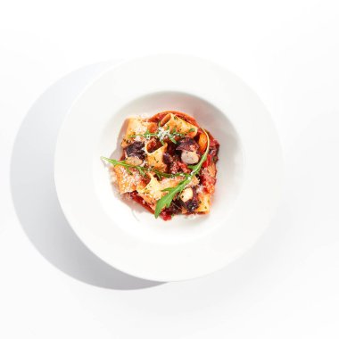 Deniz ürünleri ve parmesan peynirli Cannelloni makarnası. Domates sosu ve kızarmış ahtapotla doldurulmuş lazanya cannelloni makarnası. Beyaz arka planda izole edilmiş beyaz tabakta İtalyan makarnası 