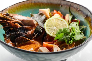 Tom yum veya Tom yer elması - karışık deniz ürünleriyle sıcak ve ekşi Tayland çorbası. Tayland geleneksel karides ve hindistan cevizi sütü çorbası. Tom beyaz arka planda nefis. Beyaz arka planda izole edilmiş çorba tabağı.. 
