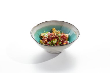 Ton balığı ve salatalık kasesi. Mavi salata kasesi beyaz arka planda izole edilmiş. Mikro yeşillik ve susam ile süslenmiş salata, doğranmış ton balığı, dilimlenmiş salatalık ve maydanoz yeşil yaprak. Baharatlı soslu çiğ ton balığı.