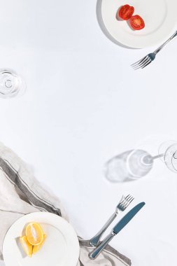 Beyaz masa örtülü restoran ya da kafe masası manzarası. Boş kafeterya masası. Güneş ışığı ve yukarıdan sert gölge manzaralı. Kafe konseptinde yaz günü. Kristal beyaz arkaplan