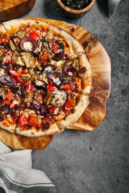 Soğanlı ve mevsimlik sebzeli barbekü pizzası. Ahşap tepside süslenmiş