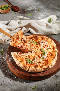 İtalyan Deniz Ürünleri Pizzası - Ahşap tabakta karışık deniz mahsullü pizza. Gri zemin üzerinde kırsal deniz ürünleri pizzası. Güneş ışığı ve sert gölge.