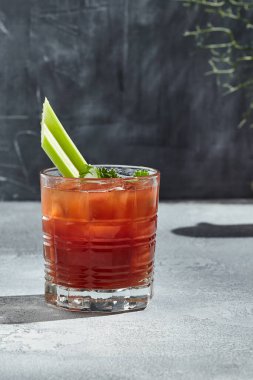 Red Bloody Mary Cocktail, votka ve domates suyuyla birlikte az alkollü bir kokteyl. Güneş ışığı ve gölgesi olan eski bir masa. Bloody Mary ya da Virgin Mary içeceği - kerevizle süslenmiş votka bazlı kokteyl