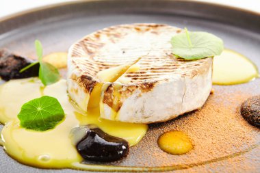 Fırında kremalı krema tabakta. Eritilmiş peyniri beyaz kabukta yakın mesafeden servis ettim. Restoran yemekleri, aperatifler. Fransız mutfağı. Kremalı, yumuşak peynir yığını. İnek sütü ürünleri bölümü