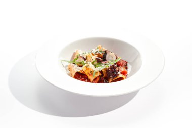 Deniz ürünleri ve parmesan peynirli Cannelloni makarnası. Domates sosu ve kızarmış ahtapotla doldurulmuş lazanya cannelloni makarnası. Beyaz arka planda izole edilmiş beyaz tabakta İtalyan makarnası 