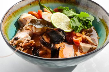 Tom yum veya Tom yer elması - karışık deniz ürünleriyle sıcak ve ekşi Tayland çorbası. Tayland geleneksel karides ve hindistan cevizi sütü çorbası. Tom beyaz arka planda nefis. Beyaz arka planda izole edilmiş çorba tabağı.. 