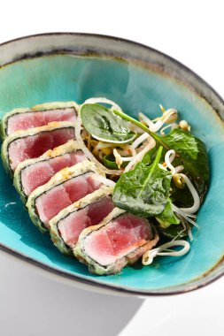 Ton balığı, kızarmış ton balığı. İnce dilimlenmiş sashimi tarzı. Lezzetli turunçgil ponzu tataki soslu ton balıklı tataki. Siyah tabakta Japon deniz ürünleri beyaz arka planda izole edilmiştir.