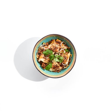 Pan-Asya geleneksel yemeği - yumurta, sebze ve kalamar ile kızartılmış pirinç. Beyaz arka planda pirinç, yumurta ve kalmar ile Hint tavası. Nasi goreng ve kalamar izole edilmiş arka planda gölgeler