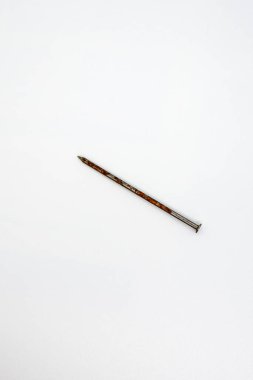 Beyaz arka planda tek bir paslı çivi