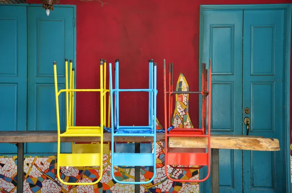 Красочные стулья на деревянном столе — стоковое фото