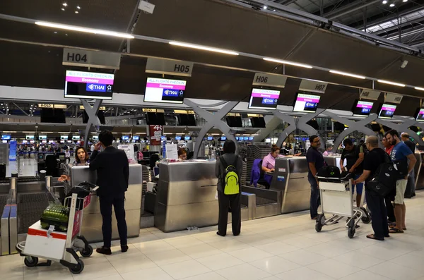 Onbekende passagiers aankomen bij de check-in balies op het nieuwe Suvarnabhumi Airport in Bangkok — Stockfoto