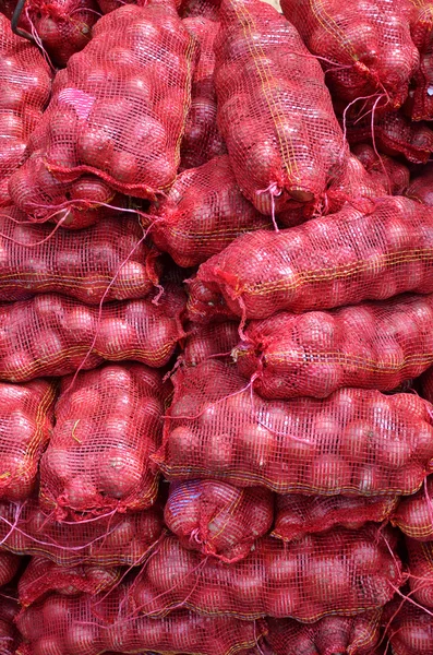 Säcke mit großen Zwiebeln gestapelt zum Verkauf — Stockfoto