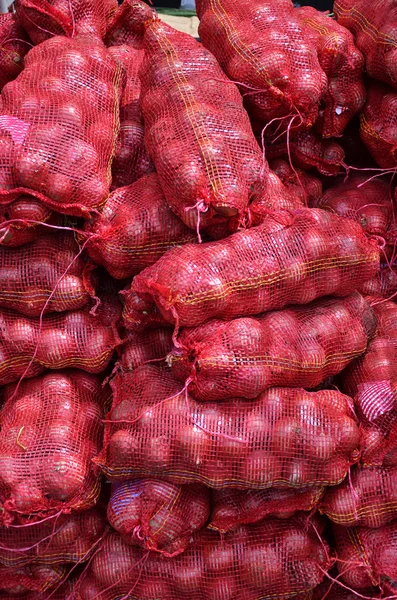 Säcke mit großen Zwiebeln gestapelt zum Verkauf — Stockfoto