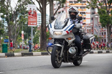 Singapur, 08 Kasım 2020: Tanımlanamayan polis memuru Singapur Ulusal Gün Mobil Kolonu 'nda motosiklet sürüyor.