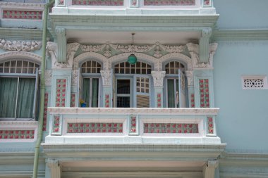 Singapur - 19 Mart 2021: Geleneksel Peranakan veya Boğaz Çin Singapur atölyesinin önü, tarihi Küçük Hindistan 'da beyaz ahşap panjurlu ve sütunlu kemerli..