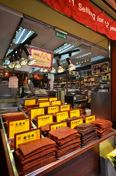 Shop-keeper säljer sortiment av kinesiska konserverat kött i Macau — Stockfoto