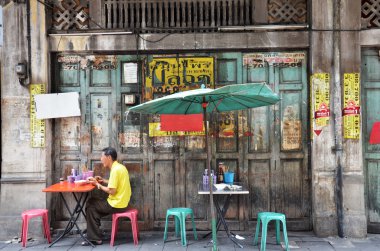 Unidentified man eats on a street clipart