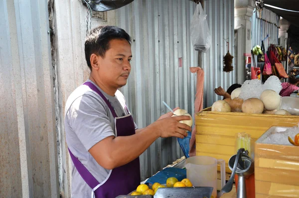 Продавец уличных кокосовых соков продает свежий кокос — стоковое фото