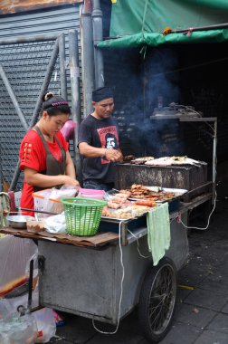 Kimliği belirsiz bir sokak satıcısı yol kenarındaki bir restoranda yemek yapıyor 