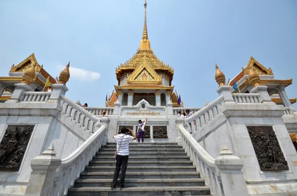 Люди посещают Wat Traimit — стоковое фото