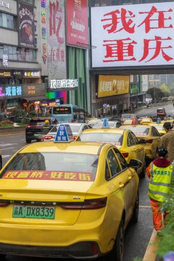 Chongqing, China- 9 Kasım 2025: Çin 'in Chongqing bölgesindeki Guangyingqiao bölgesinde müşteriler için ikonik sarı taksi kuyruğu. 