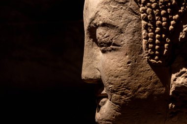 Buddha 'nın yüzünü, Çin' in Chongqing kentindeki Dazu Taş Oyma Müzesi 'nde koyu arkaplan ile kapatın. Müze, Dazu Kaya Oymaları 'nın koleksiyonu, korunması ve araştırılması üzerine yoğunlaşmıştır.