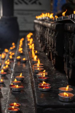 Chongqing, Çin 'deki Louhan Tapınağı' nda mum yakmak. Mum ya da tütsü yakmak Buda 'ya saygıyı, barış dualarını ve bilgeliğin ışığını simgeler.