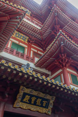 Singapur - 5 Aralık 2025: Singapur 'daki Buda Dişi Tapınağı manzarası. Beş kat yüksekliğinde, karmaşık detaylar, renkli süslemeler ve görkemli kırmızı-altın bir cepheyle övünüyor.