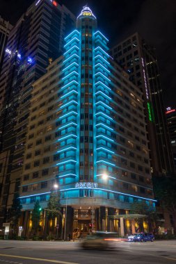 Singapur - 5 Aralık 2025: Ascott Raffles Singapur 'da mavi ışıkla aydınlatıldı. Bir zamanlar Güney Doğu Asya 'nın en yüksek binası olan 1950' lerden kalma eski bir miras yapısına ev sahipliği yapmaktadır.