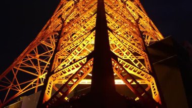 Tokyo, Japonya- 22 Aralık 2025: Tokyo Kulesi sıcak turuncu renkle aydınlanıyor. Dik durarak, şehir manzaralarını süpürüyor, özellikle de karanlık çöktüğünde, Tokyo 'yu sıcak ve büyüleyici bir şekilde aydınlatıyor.