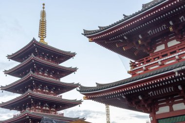Tokyo, Japonya- 16 Aralık 2025: Asakusa, Tokyo 'daki Sensoji Tapınağı' nda mavi gökyüzü ile beş katlı yükselen pagoda. Japonya 'nın en uzun pagodalarından biridir ve tapınağın zengin tarihini sembolize eder.